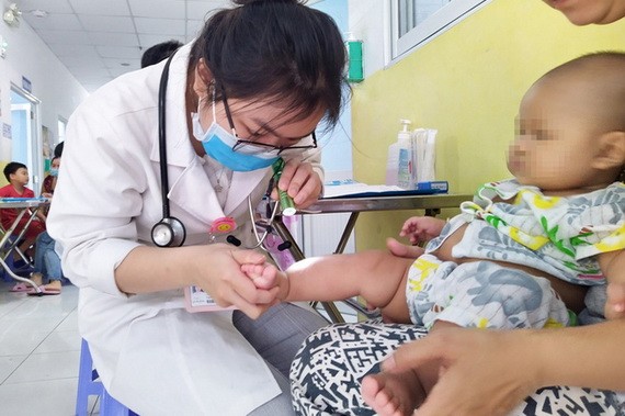 市第一兒童醫院的醫生在為一名患有疑似手足口病的病童看診。（圖源：英舒）