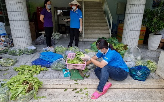 防疫隊伍的婦女正在包裝蔬菜送到隔離區。