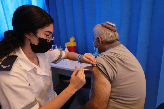 8月17日，一名男子在以色列中部城市莫迪因的一處接種點接種第三劑新冠疫苗。（圖源：新華社）