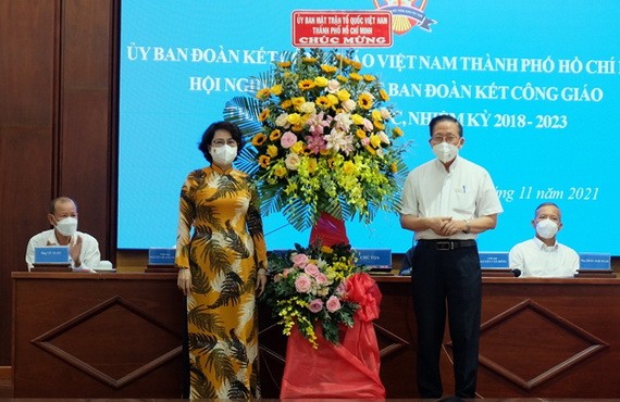 市越南祖國陣線委員會主席蘇氏碧珠（前左）向守德市天主教團結處協商會議贈送鮮花祝賀。（圖源：秋紅）