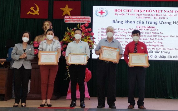 第五郡宣教處主任胡氏竹江向4個人頒發越南紅十字會獎狀。