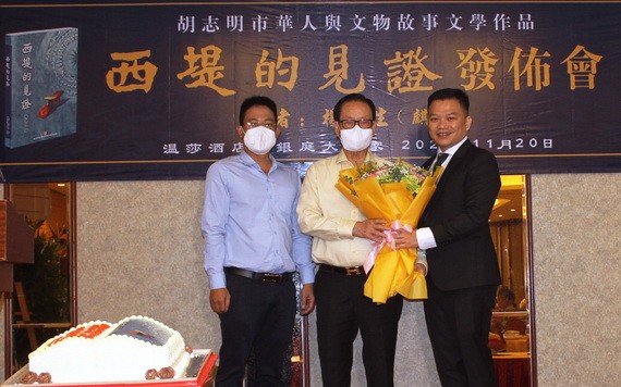 麒麟（右）向萬盛發集團代表張豐裕先生、華文《西貢解放日報》編委文忠孝贈送鮮花。