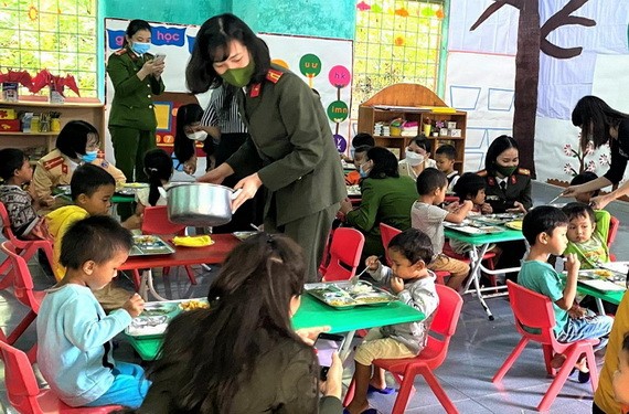廣平省公安廳女幹部向契溪分校學生贈送禮物及關照他們的午餐。