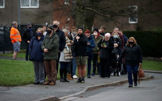 人們在英國巴克斯頓排隊等待接種新冠疫苗加強針。（圖：路透社）