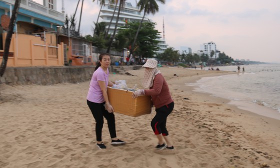 當地居民在富國島海灘撿拾塑料垃圾，美化環境。（圖：國平）