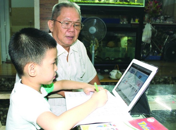 小學一年級的華人子弟居家線上學習總是有長輩陪伴。