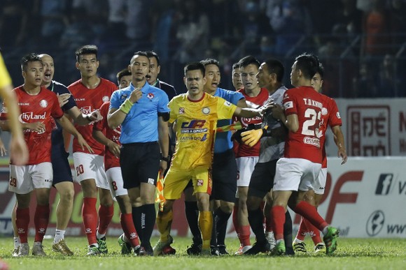 Các cầu thủ Thanh Hoá và TPHCM cản thủ môn Thành Thắng tiến đến gây sự với trợ lý trọng tài Nguyên Thành. Ảnh: MINH HOÀNG