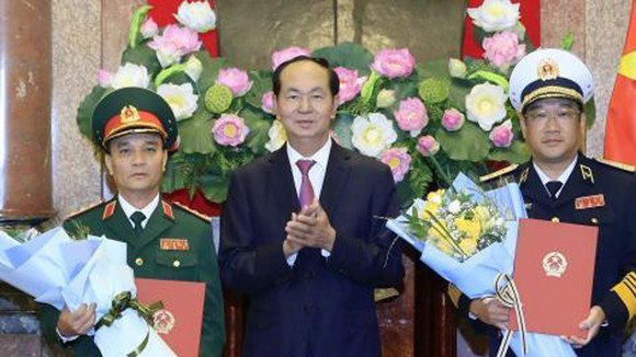 Chủ tịch nước Trần Đại Quang trao Quyết định thăng quân hàm cho đồng chí Phạm Hồng Hương và đồng chí Phạm Hoài Nam. Ảnh: Nhan Sáng/TTXVN