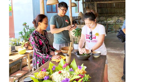 Khách thích thú trải nghiệm, tìm hiểu các loại ẩm thực  được trang trí bằng lá tại nhà dân ở tỉnh Trà Vinh 