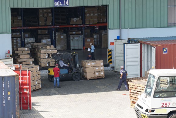 Hàng hóa tại kho vận Tân Cảng - Cát Lái đang được vận chuyển xuất nhập vào các container. Ảnh: HOÀNG HÙNG