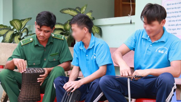 Anh Đinh Văn Tiến (trái) hướng dẫn học viên  trong một buổi lao động trị liệu