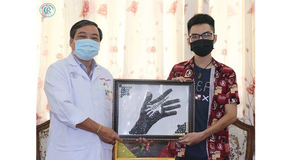Anh Nguyễn Phước Quý Thành trao tặng tranh cho đại diện Bệnh viện Chợ Rẫy TPHCM.