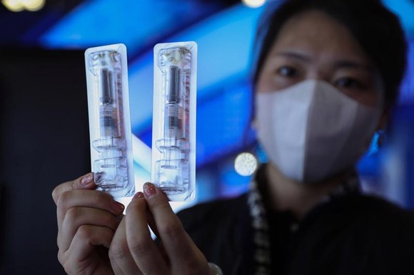 Một nhân viên công ty Walvax đang cầm vaccine Covid-19 của công ty - Ảnh: Getty Images