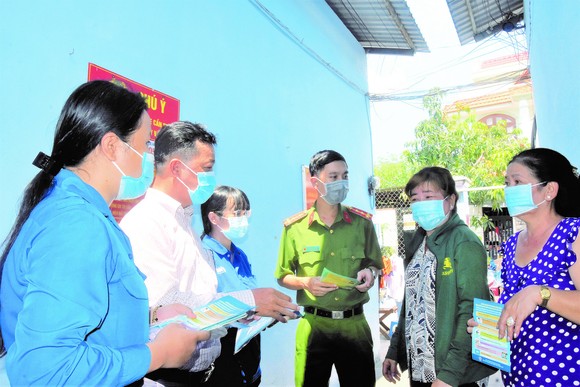 Ông Lê Hoàng Long (thứ hai từ trái qua) cùng các tổ viên tuyên truyền về công tác phòng chống dịch cho người dân ở dãy nhà trọ Nghinh Phong tại ấp 5, xã Phú Xuân, huyện Nhà Bè, TPHCM