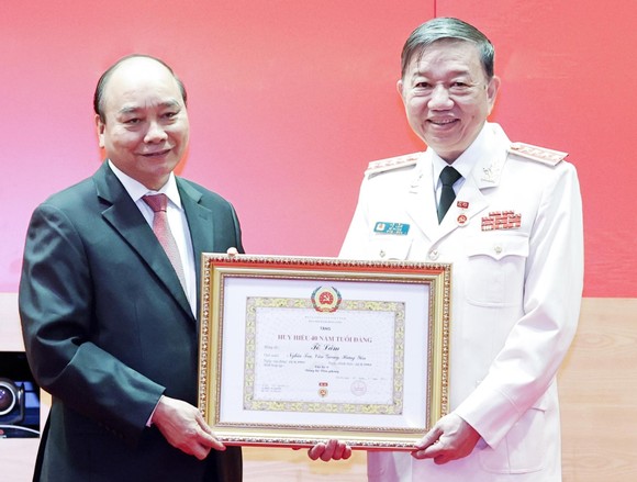 Chủ tịch nước Nguyễn Xuân Phúc trao tặng Huy hiệu 40 năm tuổi Đảng cho Đại tướng Tô Lâm, Bộ trưởng Bộ Công an. Ảnh: TTXVN