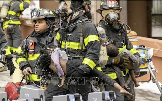 Lính cứu hỏa sơ tán các em nhỏ tại hiện trường vụ hỏa hoạn. Ảnh: Nydailynews.com/TTXVN