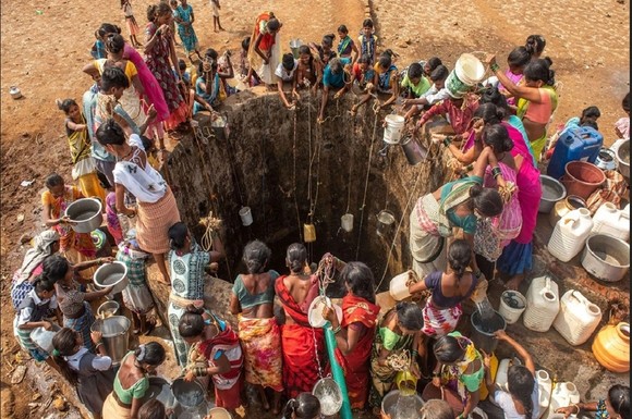 Người dân ở Mumbai, Ấn Độ xếp hàng lấy nước quanh một chiếc giếng. Ảnh: SIPA 