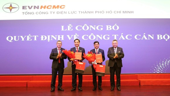 Ông Bùi Hải Thành và ông Nguyễn Thanh Nhã nhận quyết định và hoa chúc mừng từ Chủ tịch EVNHCMC Phạm Quốc Bảo (bìa phải) và Tổng Giám đốc EVNHCMC Nguyễn Văn Thanh (bìa trái)
