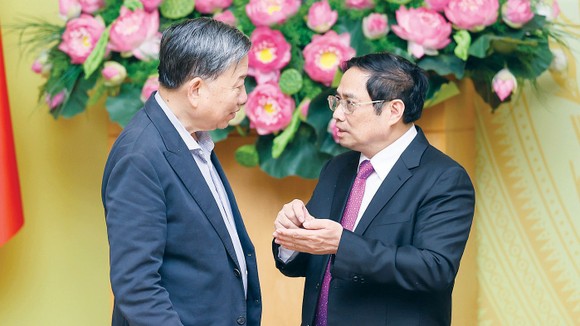 Thủ tướng Phạm Minh Chính trao đổi với Bộ trưởng Bộ Công an Tô Lâm tại phiên họp. Ảnh: ĐOÀN BẮC