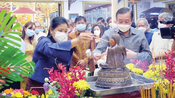 Bà Wiraka Mudhitaporn, Tổng lãnh sự Thái Lan tại TPHCM (trái), thực hiện nghi thức tắm Phật tại lễ hội. Ảnh: TTXVN