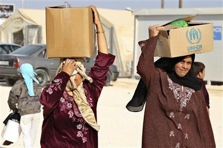 Người tị nạn Syria tại trại tị nạn Zaatari, thành phố Mafraq, Jordan, giáp biên giới Syria nhận hàng viện trợ của Liên hiệp quốc ngày 22-10-2012. Ảnh: REUTERS