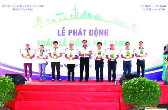 Ông Huỳnh Tấn Lộc (thứ ba từ phải qua) - đại diện Vedan Việt Nam - đang nhận những phần quà là cây xanh từ Ban tổ chức chương trình
