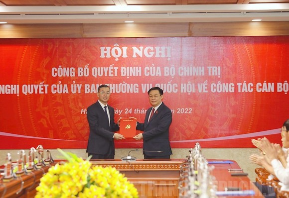 Chủ tịch Quốc hội Vương Đình Huệ trao quyết định và chúc mừng đồng chí Ngô Văn Tuấn. Ảnh: www.hcmcpv.org.vn