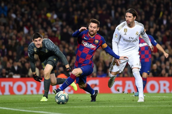 Lionel Messi  tranh bóng với Sergio Ramos và thủ thành Thibaut Courtois