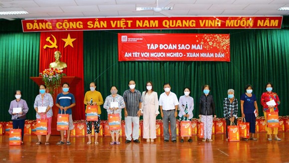 Bà Lê Thị Nguyệt Thu - Chủ tịch Tập đoàn Sao Mai ( thứ 7 bên phải qua) tặng quà cho bà con nghèo TP Long Xuyên