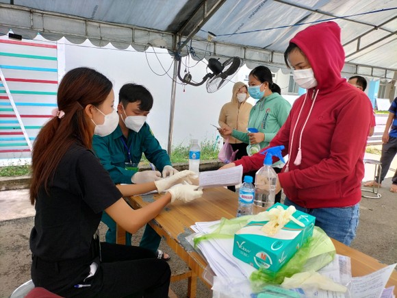 Người dân khai báo y tế trước khi tiêm vaccine ở phường Đông Hòa, TP Dĩ An