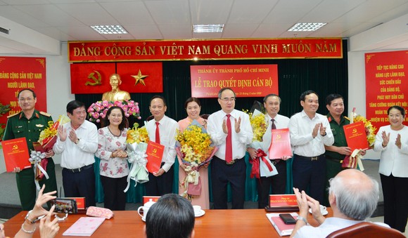Bí thư Thành ủy TPHCM Nguyễn Thiện Nhân cùng các đồng chí lãnh đạo TP chúc mừng các đồng chí nhận quyết định. Ảnh: Việt Dũng