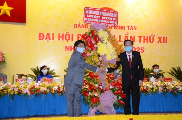 Phó Chủ tịch Thường trực UBND TPHCM Lê Thanh Liêm tặng hoa, chúc mừng Đại hội đại biểu Đảng bộ quận Bình Tân. Ảnh: KIỀU PHONG