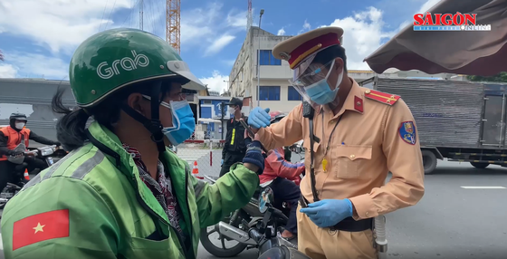 Lực lượng chức năng TPHCM kiểm tra một shipper trong ngày 26-7. Ảnh: VĂN MINH