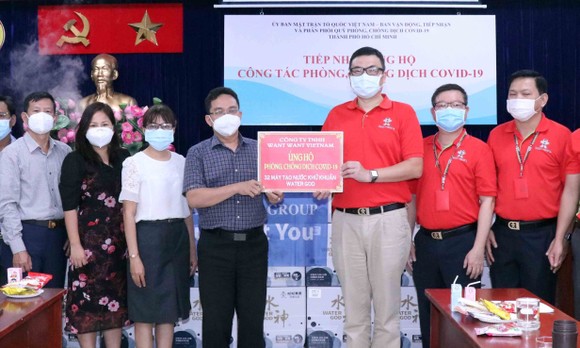 Phó Chủ tịch Ủy ban MTTQ Việt Nam TPHCM Phạm Minh Tuấn tiếp nhận bảng tượng trưng ủng hộ từ nhà tài trợ