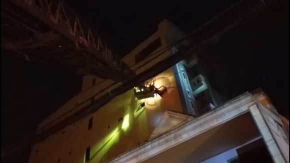 Lực lượng dùng xe thang tiếp cận đưa 24 người mắc kẹt trong vụ cháy chung cư mini ra ngoài an toàn. Ảnh: C.T
