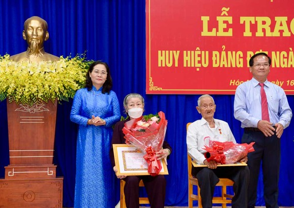 Chủ tịch HĐND TPHCM Nguyễn Thị Lệ trao Huy hiệu 75 năm tuổi Đảng cho đồng chí Lê Văn Nghi và Huy hiệu 60 năm tuổi Đảng cho đồng chí Chu Thị Ngọ. Ảnh: CAO THĂNG