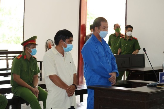 Bị cáo Phạm Văn Cung (áo xanh) và bị cáo Nguyễn Tuấn Sĩ tại phiên tòa sơ thẩm. Ảnh: QUỐC AN