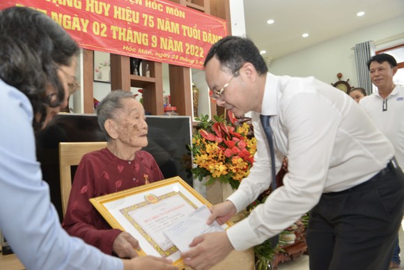 Phó Bí thư Thành uỷ TPHCM Nguyễn Văn Hiếu trao Huy hiệu 75 năm tuổi Đảng cho đồng chí Trịnh Thị Tẻo. Ảnh: CAO THĂNG 