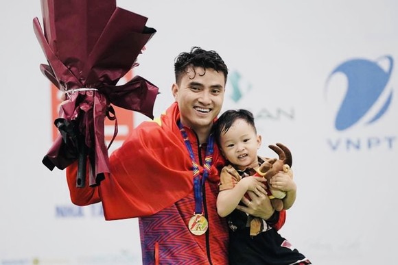 VĐV Vũ Thành An ăn mừng kết quả HCV ngày đầu tiên thi đấu tại SEA Games 31 cùng con trai. Ảnh: ĐỖ TRUNG