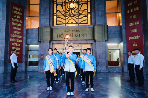 Đinh Phương Thành (cầm đuốc) và các VĐV đã thực hiện nghi lễ xin lửa tại Bảo tàng Hồ Chí Minh. Ảnh: N.TÚ