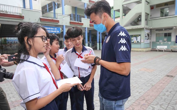 Thủ môn Bùi Tiến Dũng và đội trưởng Văn Thuận sẻ chia  với học sinh gặp tai nạn trường THCS Bạch Đằng  ảnh 5