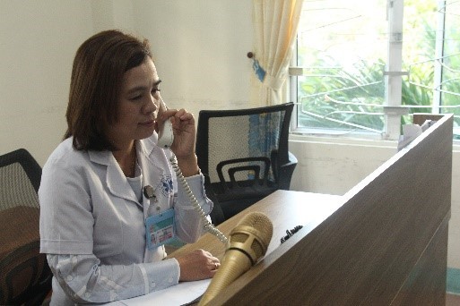 Bác sĩ Phan Thị Thanh Thủy đang tư vấn cho một người dân về cách phòng chống Covid-19 tại bàn trực 