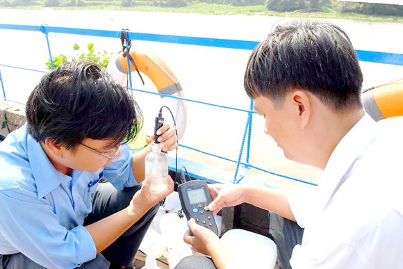 Lực lượng chức năng ở TPHCM kiểm tra chất lượng nước lấy từ sông Sài Gòn đoạn qua huyện Củ Chi. Ảnh: CAO THĂNG