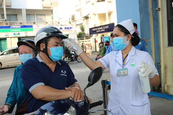 Người bệnh vào Bệnh viện Da liễu TPHCM phải bắt buộc đeo khẩu trang và được kiểm tra thân nhiệt, khai báo y tế ngay từ cổng. Ảnh: MINH NAM