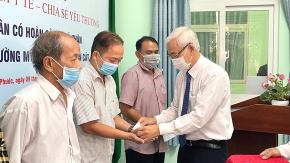 Ông Phạm Ngọc Thuận, đại diện Tổng công ty Becamex IDC trao BHYT đến bà con gặp khó khăn 