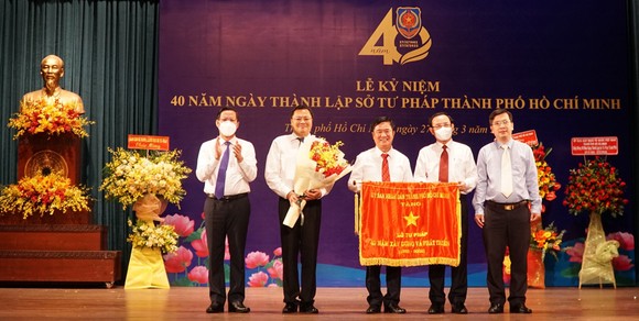 Bí thư Thành ủy TPHCM Nguyễn Văn Nên, Chủ tịch UBND TPHCM  Phan Văn Mãi trao cờ truyền thống của UBND TPHCM cho Sở Tư pháp. Ảnh: MAI HOA