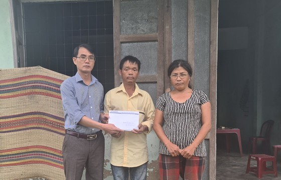 Đại diện Báo SGGP tại miền Trung trao tặng tiền bạn đọc hỗ trợ vợ chồng anh Phùng Ngọc Sơn. Ảnh: NGUYỄN CƯỜNG 