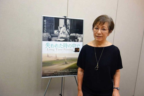 Đạo diễn Masako Sakata bên cạnh poster phim Long Time Passing
