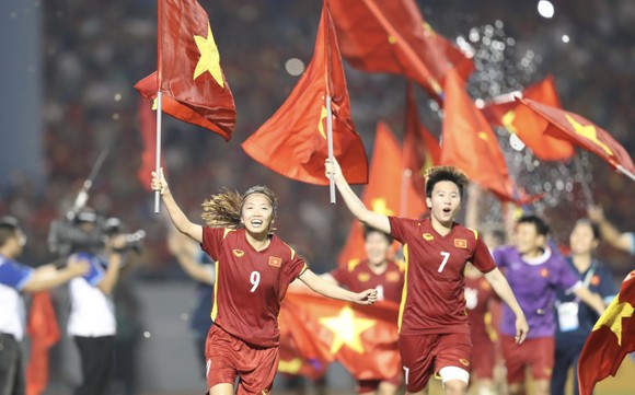 Huỳnh Như và Tuyết Dung cầm cờ tổ quốc ăn mừng chiến thắng. ẢNH: DŨNG PHƯƠNG