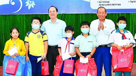 Nguyên Phó Thủ tướng Thường trực Trương Hòa Bình và  Phó Bí thư Thành ủy TPHCM Nguyễn Hồ Hải tặng quà học sinh. Ảnh: VIỆT DŨNG